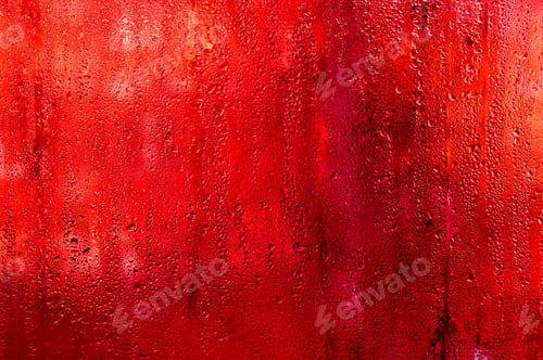 Preview: Red glass covered with rain droplets creating bright abstract texture,