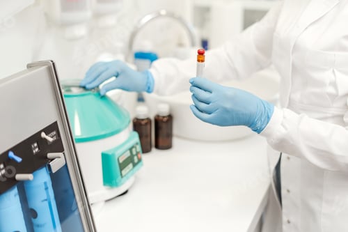 Preview: Laboratory technician, nurse or doctor holding test tube, standing in equipped medical laboratory