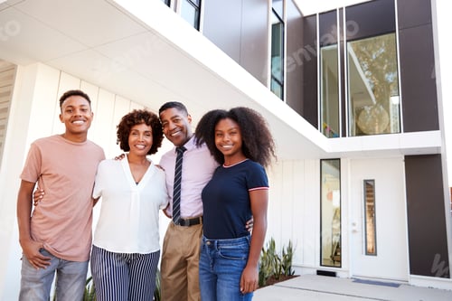 Aperçu: Black family stand looking to camera in front of their modern home,close up