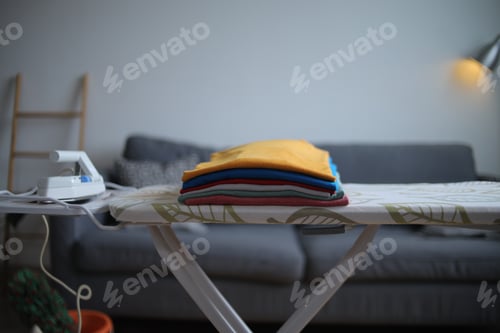 Preview: Close Up Of Folded Clothes Neatly Arranged On Ironing Board At Living Room