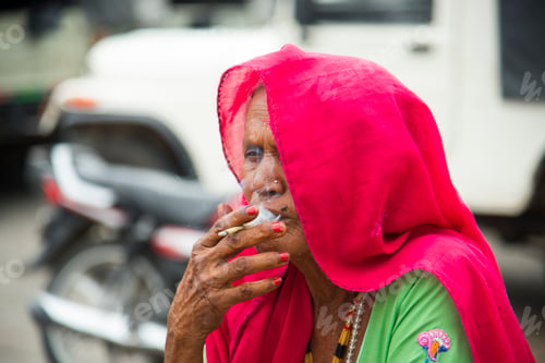 Preview: Old age woman smoking Indian handmade cigarette.
