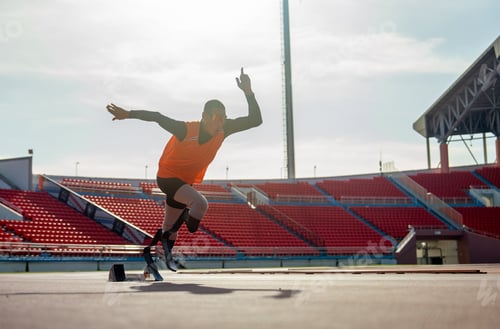 Preview: Sport man athlete prosthesis legs start run with look forward at the stadium with soft light