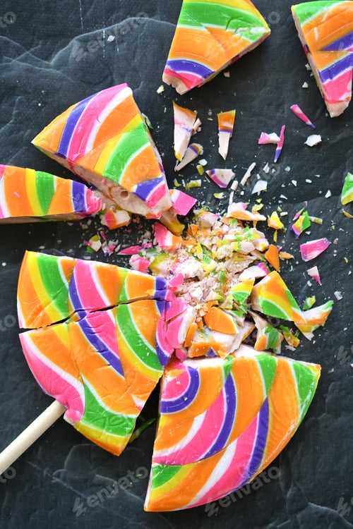 Preview: Smashed shattered colorful lollipop, dark background. Concept - childhood trauma abuse neglect