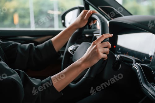 Preview: Close up view of woman hands that are driving new car