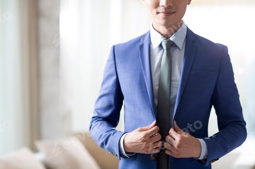 Preview: Young businessman getting dressed in the morning