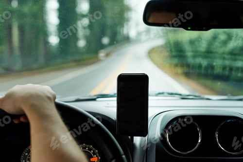Preview: Cropped shot of a man using his phones gps system while driving a car
