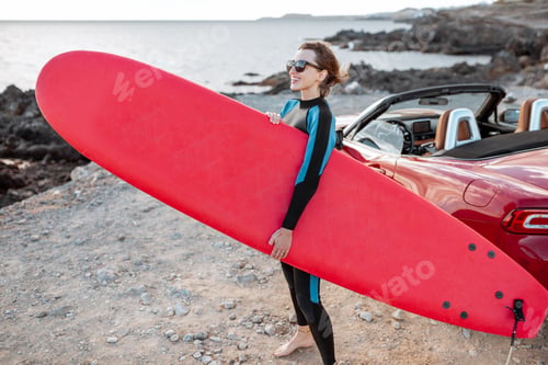 Preview: Woman with surfboard on the coast