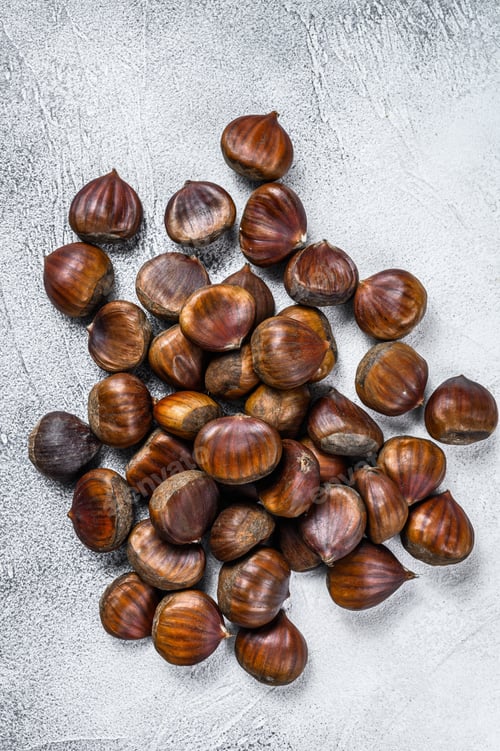 Preview: Raw chestnuts on a wooden table. White background. Top view