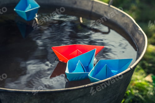 Preview: Handmade paper boats on water as unusual travel concept