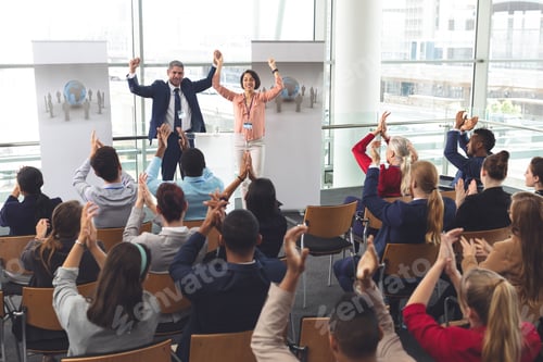 Preview: Diverse business people applauding in front of diverse business executives holding arms up