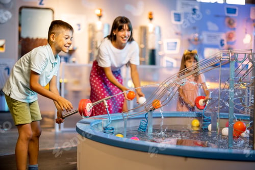 Preview: Mom with kids playing in a science museum