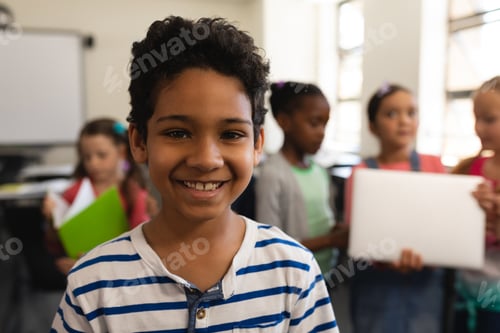 Visualização: Estudante feliz olhando para a câmera na sala de aula do ensino fundamental