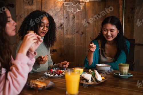 Preview: Group of friends having a brunch in coffee shop. They are eating acai bowl, waffle and sandwich