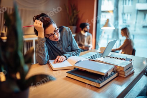 Preview: Tired Woman Studying at Table with Books