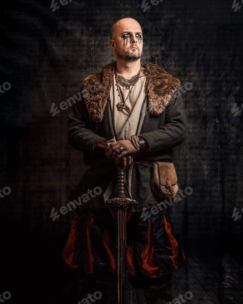 Preview: Man dressed in authentic medieval armor sitting against dark background