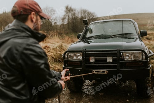 Preview: Man pulling the car towing cable