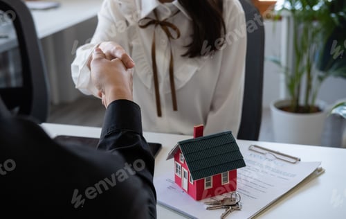 Preview: Estate agent and customer shaking hands after fafter signing contract about home insurance and