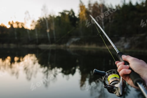 Preview: Fishing. Fisherman with rod, spinning reel on the river bank. Fishing for pike, perch, carp. Fog