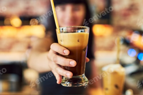 Preview: Serving gorgeous yummy drinks. Shot of a young waitress working behind the counter at a bar.