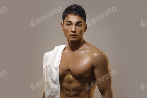 Preview: Tired Muscular Asian Man Indoors Against Gray Background
