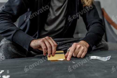Preview: cropped shot of addicted man preparing to take cocaine
