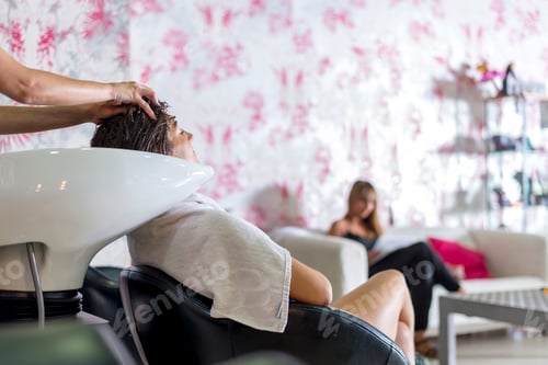 Preview: Young woman washing hair in salon