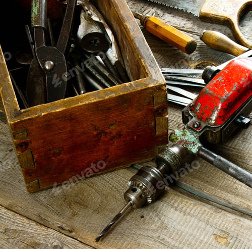 Preview: Drills in box, drill, chisel on a wooden background.