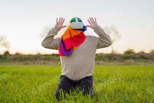 Preview: LBGT person with VR goggles in summer rural area