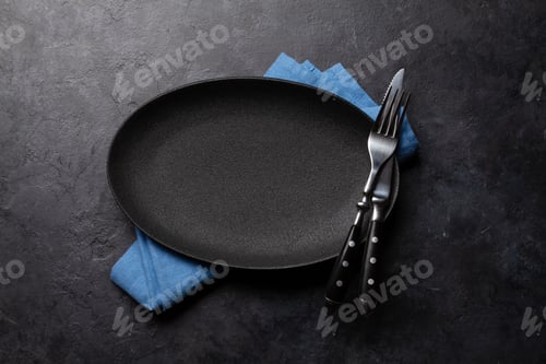 Preview: Empty plate and silverware on stone table