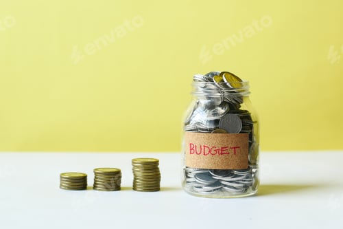 Preview: budget text on a saving coins against yellow background