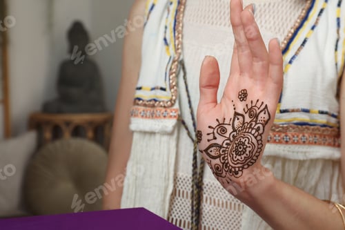 Preview: Woman with henna tattoo on palm indoors, closeup and space for text. Traditional mehndi ornament