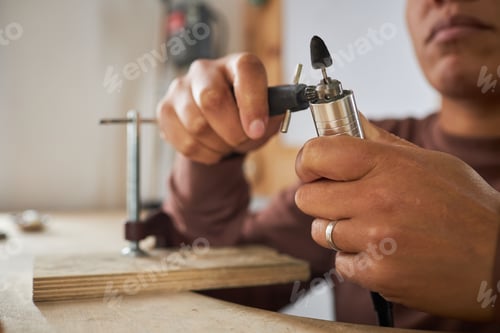 Preview: Close up of female jeweler holding tools
