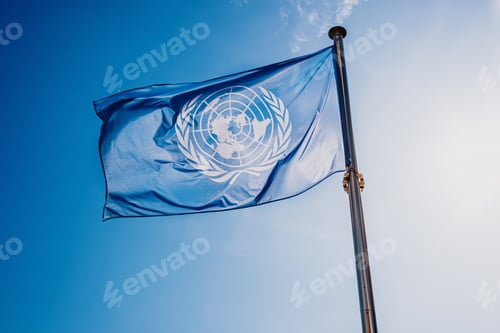Preview: UN flag waved against the sun and blue sky.
