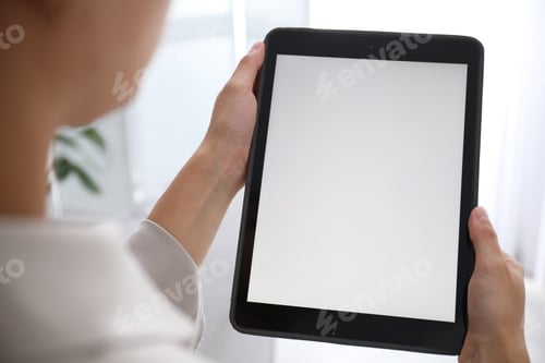 Preview: Woman using modern tablet at home, closeup. Space for design