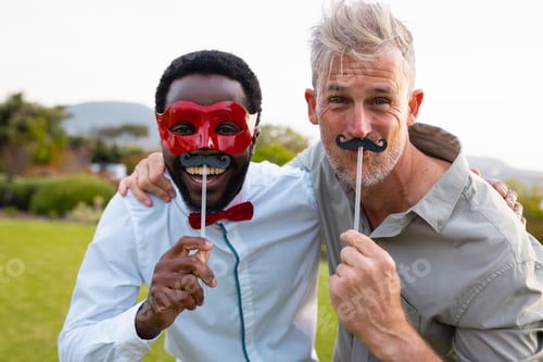 Preview: Portrait of happy diverse friends with fake moustache