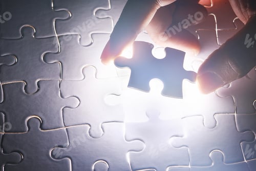 Preview: Bringing it all together. Conceptual shot of a persons hand building a puzzle.