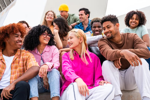 Preview: Happy playful multiethnic group of young friends bonding outdoors