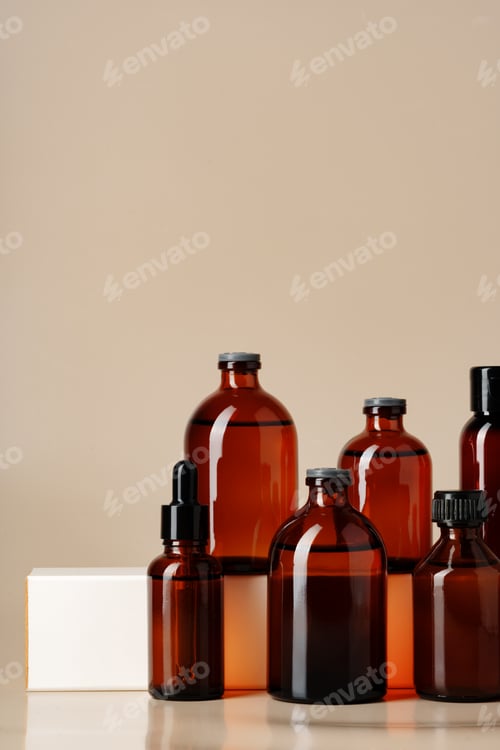 Preview: Set of brown glass bottles with essential oils on stand on beige background