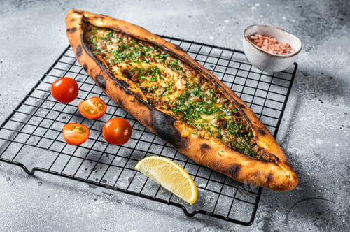 Preview: Turkish pide, traditional pie with beef meat and vegetables. White background. Top view