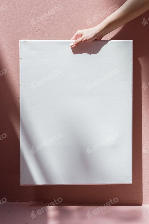 Preview: Woman holding a frame against a pink wall