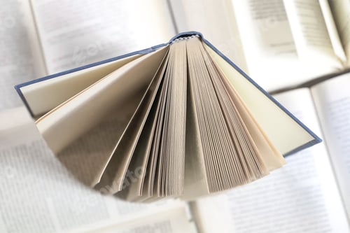 Preview: stack of books, close up. Open book on the table in library. Back to school concept. Open book on ta