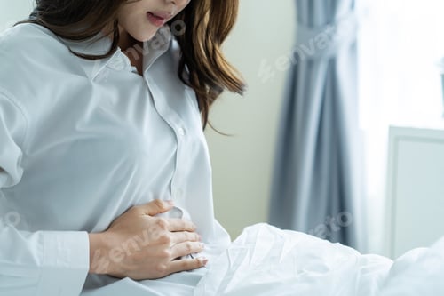 Preview: Asian young woman feel painful after wake up, having stomach ache or periods then clasping belly