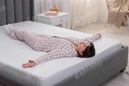 Preview: Beautiful woman lying on soft mattress at home
