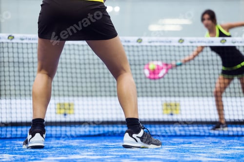 Preview: Two young women playing paddle tennis.