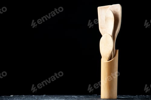 Preview: front view various wooden spoons in upright spoon rest on black background with free space