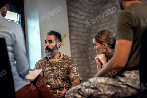 Preview: Group of diverse veterans talking during PTSD support group.