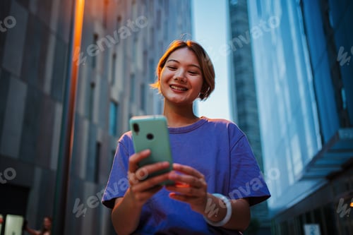Preview: Nighttime Connection: Portrait of a 20 years Asian young girl engrossed in her smart phone to browse