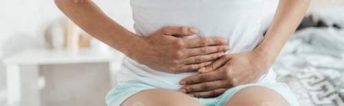 Preview: panoramic shot of woman sitting on bed and touching belly