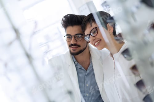 Preview: Beautiful woman with optician trying eyeglasses