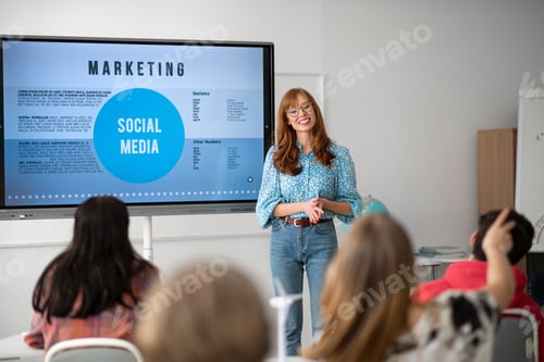 Preview: Young High school teacher giving marketing lesson to students in classroom